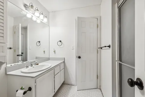a bathroom with a double vanity sink a mirror and shower