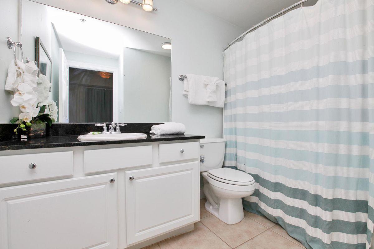15817 Front Beach Road, Unit 407W Panama City Beach, FL 32413 - Photo 11 of 23 a bathroom with a sink a toilet and a mirror
