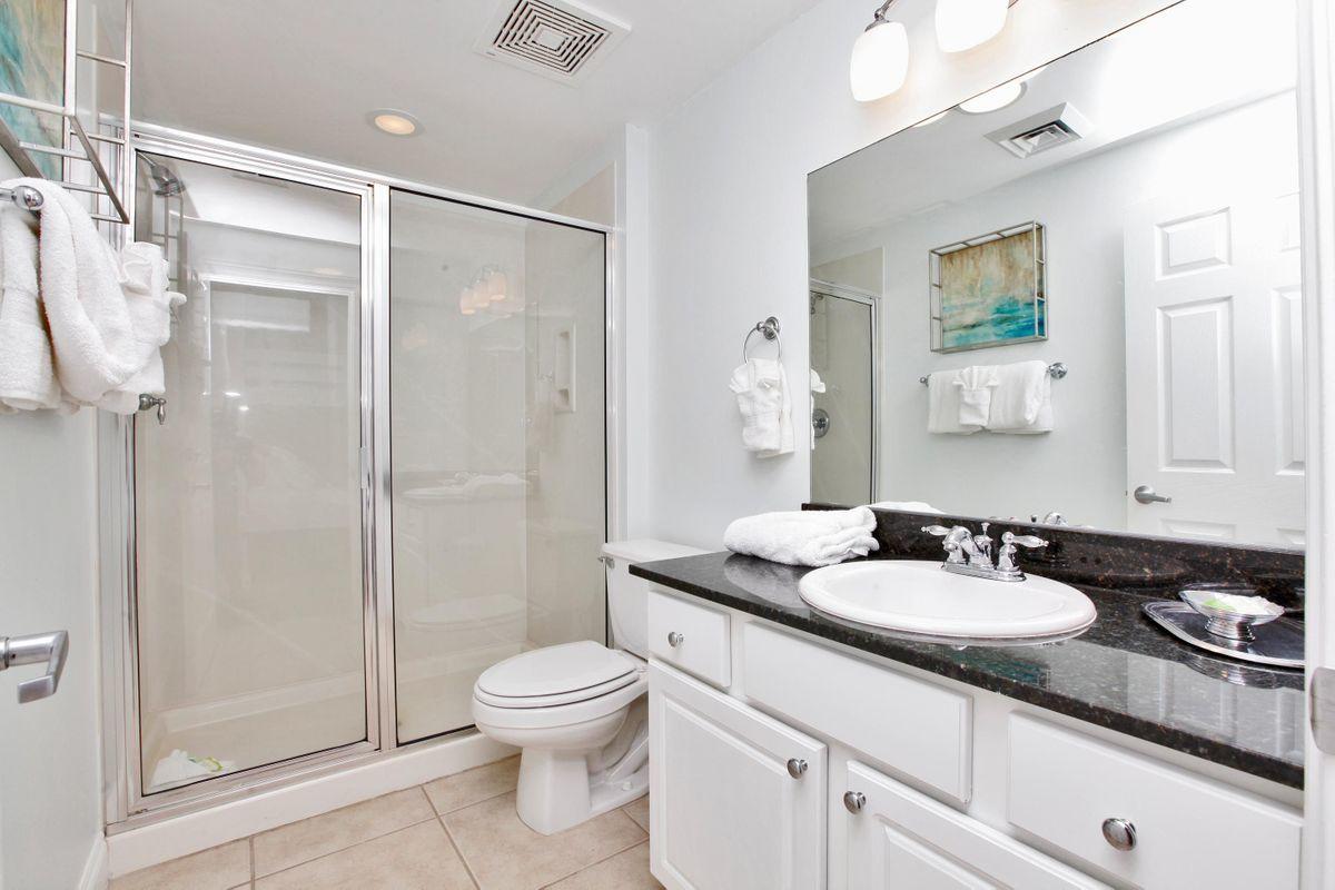 15817 Front Beach Road, Unit 407W Panama City Beach, FL 32413 - Photo 12 of 23 a bathroom with a sink toilet a mirror and shower