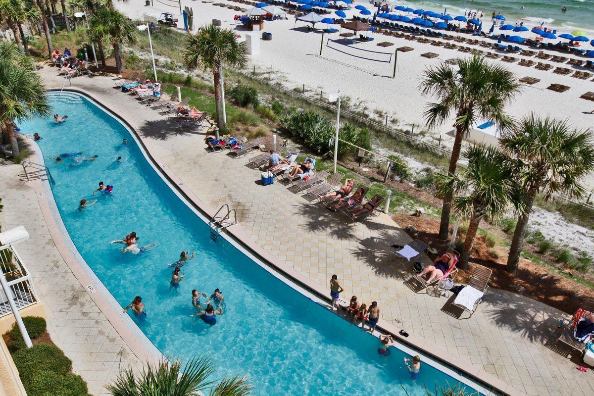 15817 Front Beach Road, Unit 407W Panama City Beach, FL 32413 - Photo 20 of 23 a view of swimming pool with chairs and wooden fence
