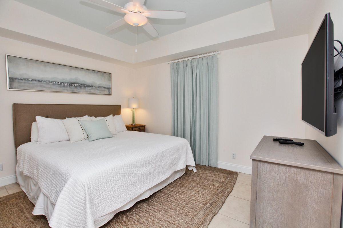 15817 Front Beach Road, Unit 407W Panama City Beach, FL 32413 - Photo 9 of 23 a bedroom with a bed and a flat screen tv