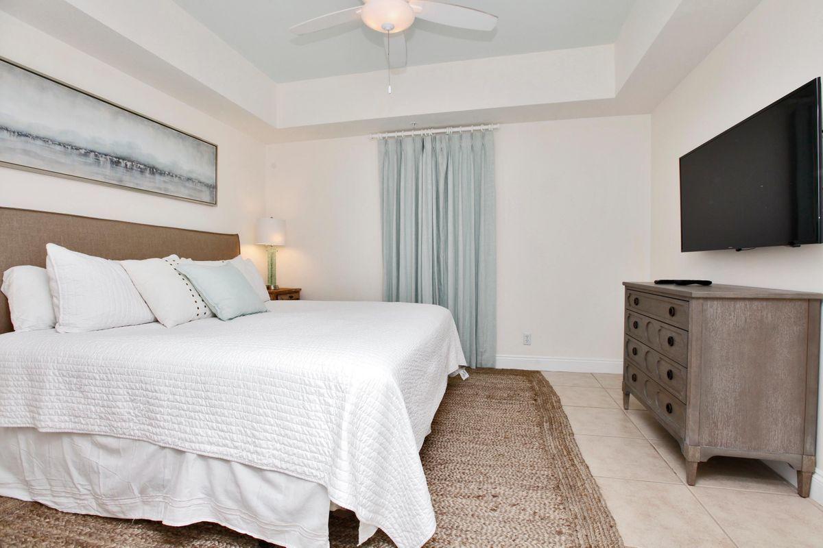 15817 Front Beach Road, Unit 407W Panama City Beach, FL 32413 - Photo 10 of 23 a bedroom with a bed and a flat screen tv