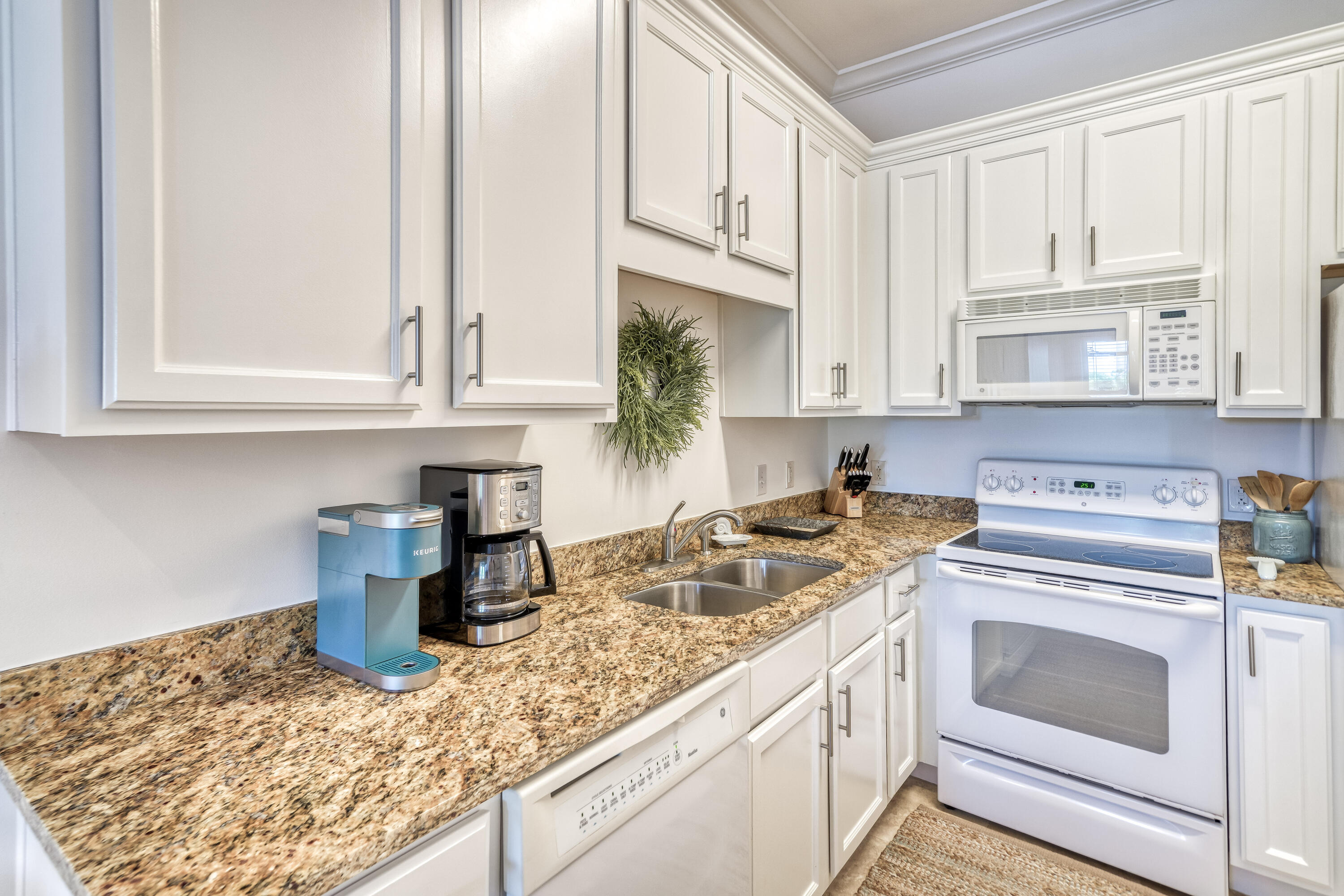 231 Somerset Bridge Road, Unit 1207 Santa Rosa Beach, FL 32459 - Photo 12 of 48 a kitchen with granite countertop white cabinets and white appliances