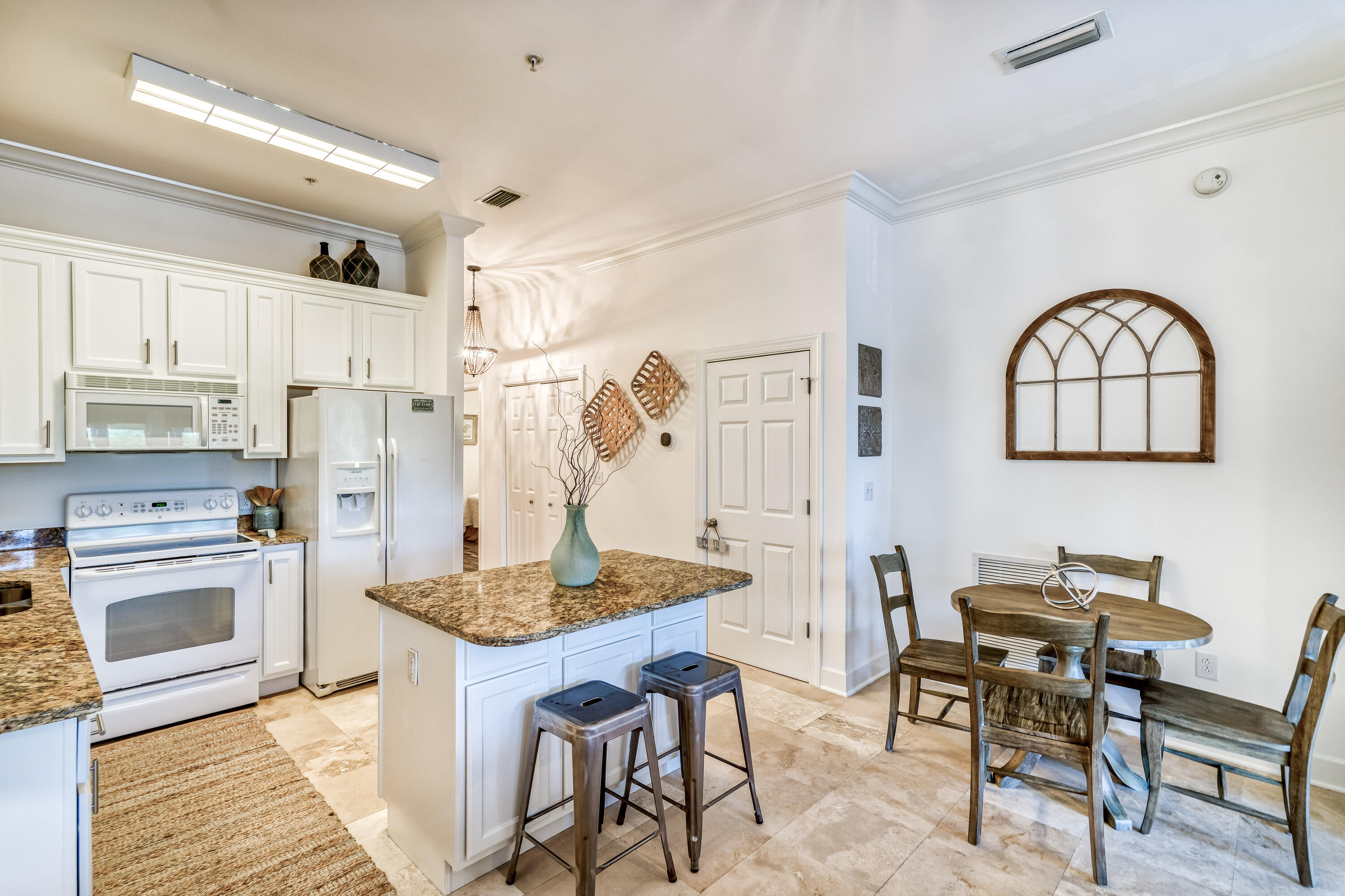 231 Somerset Bridge Road, Unit 1207 Santa Rosa Beach, FL 32459 - Photo 7 of 48 a kitchen with stainless steel appliances granite countertop a stove a refrigerator a dining table and chairs with wooden floor