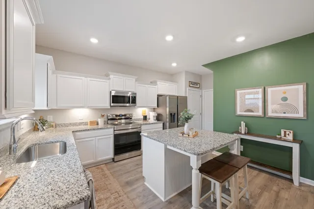 a kitchen with kitchen island a sink table and chairs