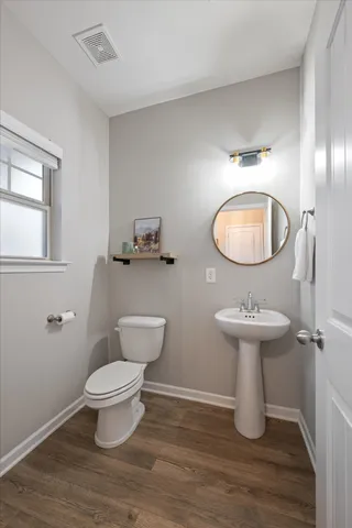 a bathroom with a toilet a sink and mirror