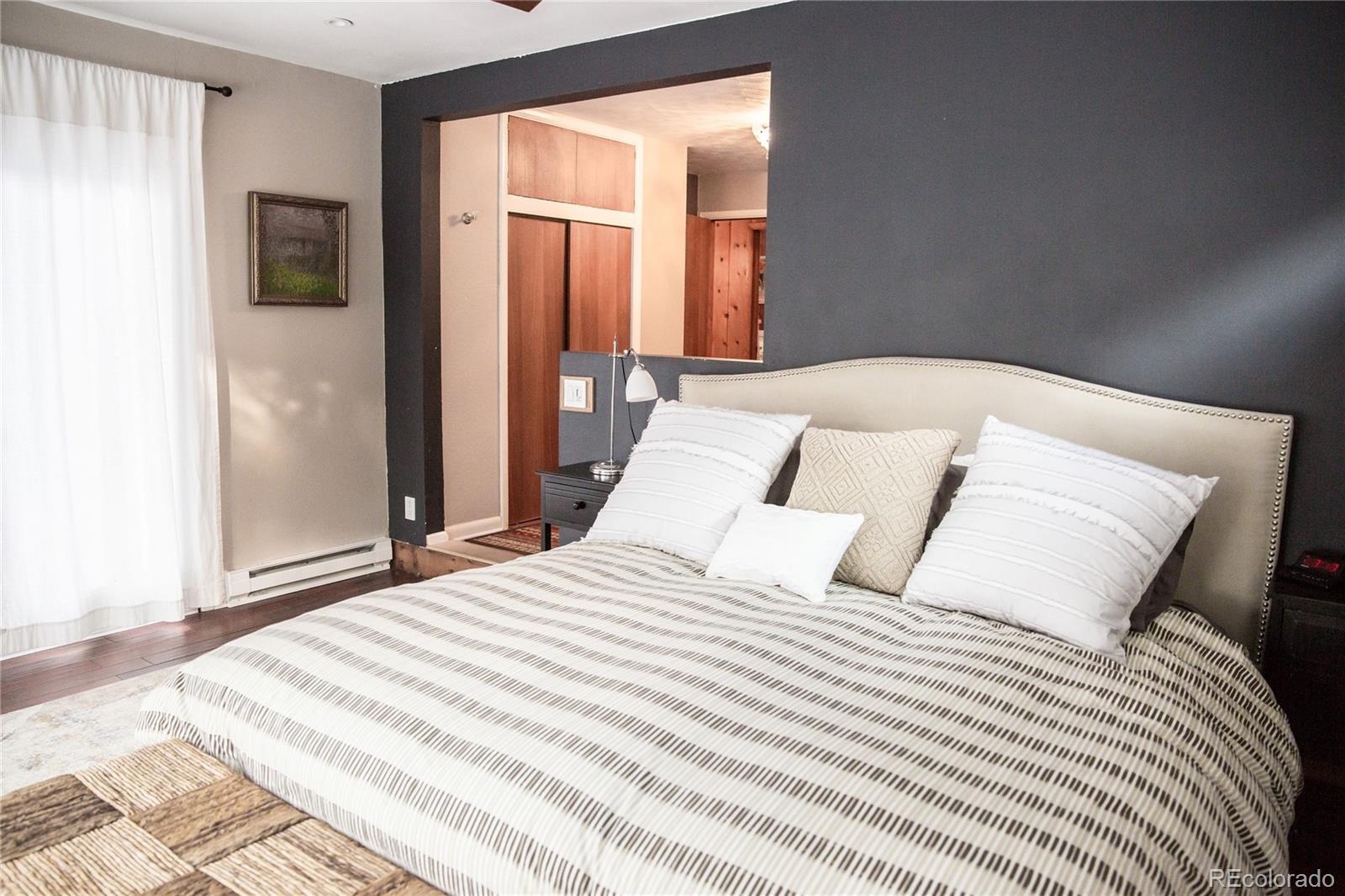 983 Cherryvale Road Boulder, CO 80303 - Photo 24 of 36 a bedroom with a large bed and a mirror