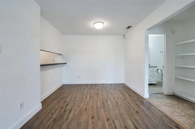 a view of empty room with wooden floor and cabinet