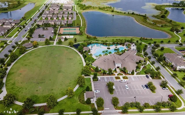 a front view of yellow house with a yard and potted plants