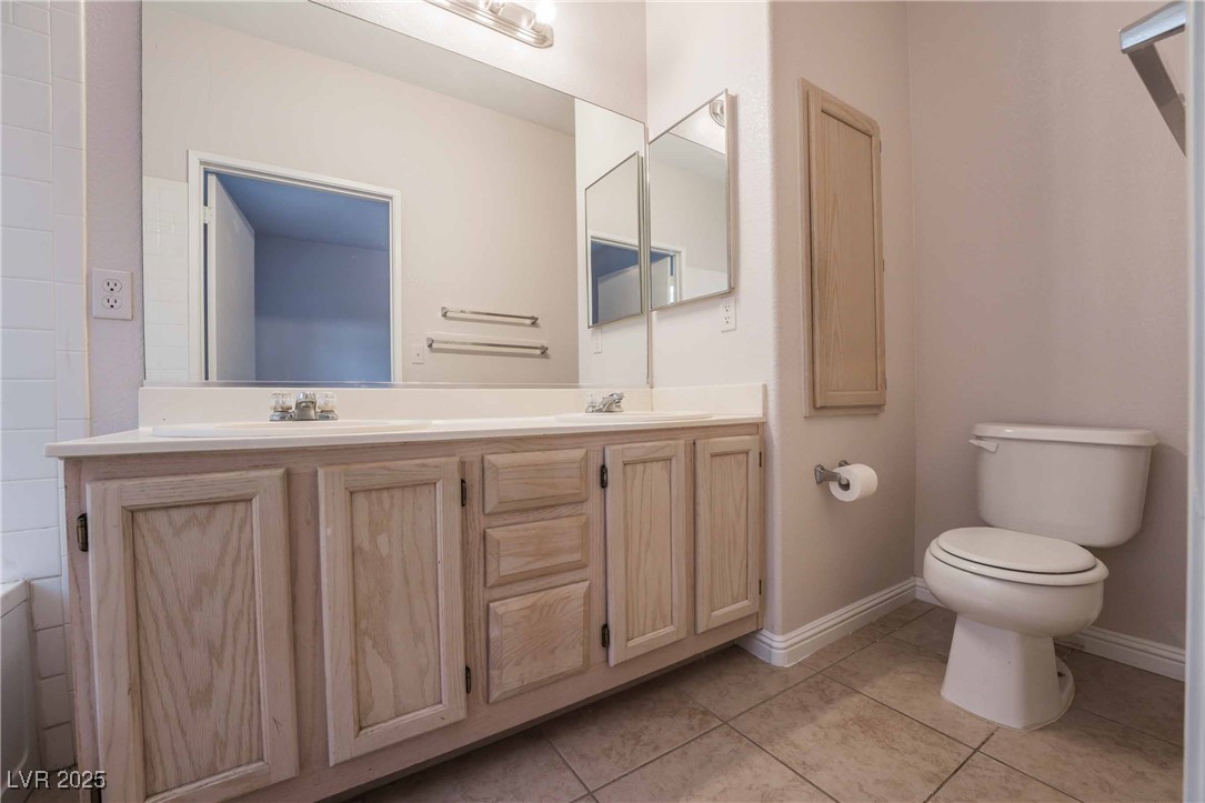 5415 West Harmon Avenue, Unit 1162 Las Vegas, NV 89103 - Photo 12 of 21 Full bathroom featuring double vanity, light tile patterned flooring, and a bathtub