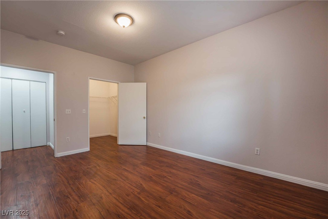 5415 West Harmon Avenue, Unit 1162 Las Vegas, NV 89103 - Photo 16 of 21 Unfurnished bedroom with dark wood-style flooring and a spacious closet