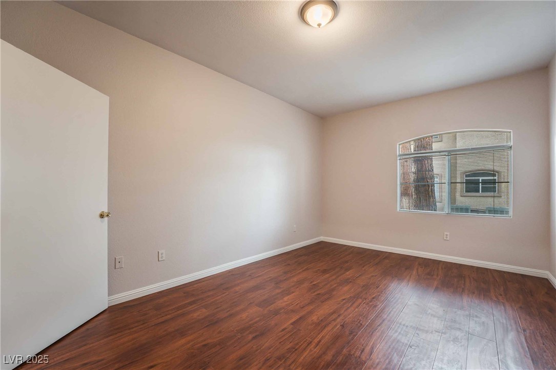 5415 West Harmon Avenue, Unit 1162 Las Vegas, NV 89103 - Photo 17 of 21 Empty room with dark wood-style floors and baseboards