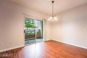 5415 West Harmon Avenue, Unit 1162 Las Vegas, NV 89103 - Photo 5 of 21 Unfurnished room featuring wood finished floors and a chandelier
