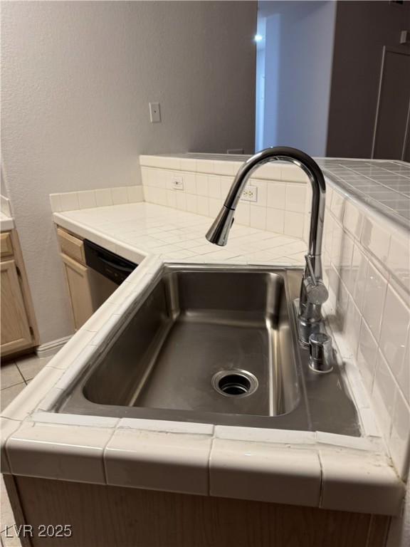 5415 West Harmon Avenue, Unit 1162 Las Vegas, NV 89103 - Photo 7 of 21 Kitchen view of tile countertops, a textured wall, and dishwasher