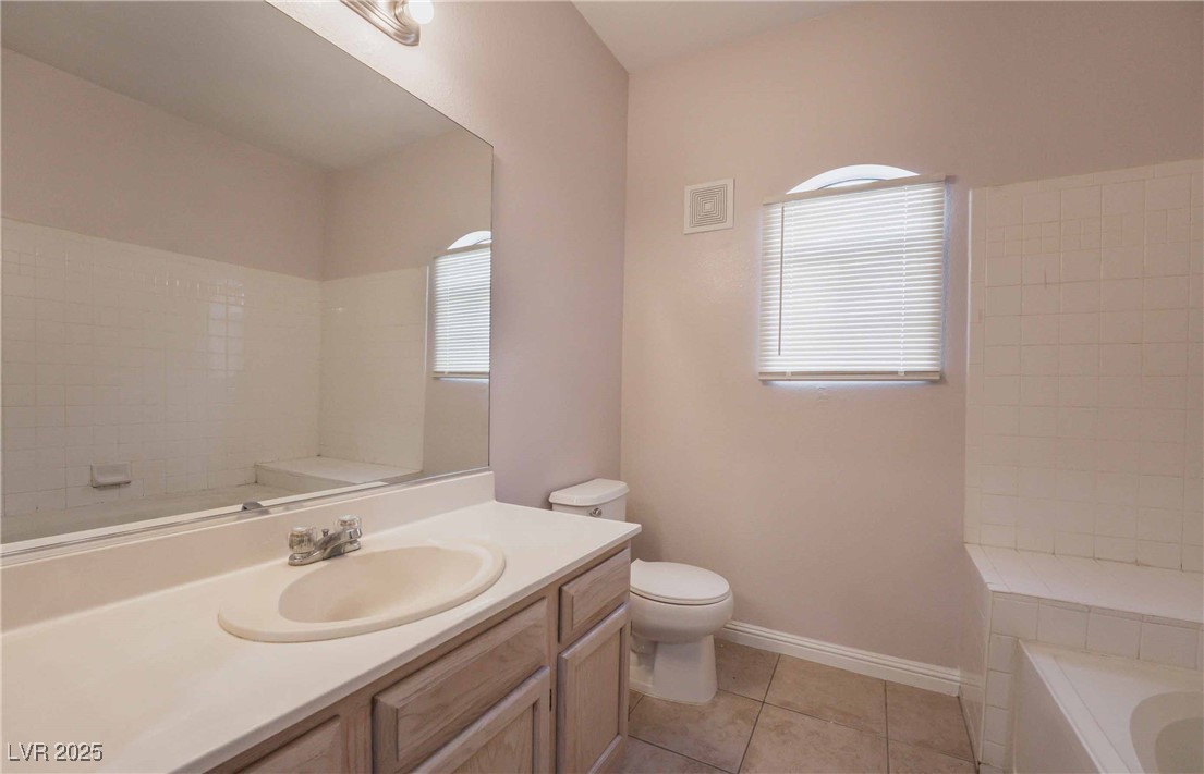 5415 West Harmon Avenue, Unit 1162 Las Vegas, NV 89103 - Photo 9 of 21 Bathroom featuring vanity, a tub to relax in, light tile patterned floors, and plenty of natural light