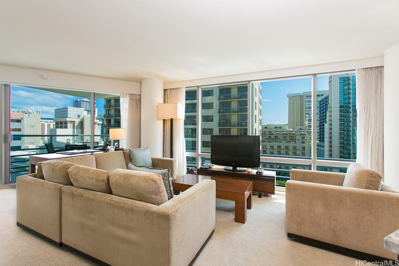 223 Saratoga Road, Unit 1202 Honolulu, HI 96815 - Photo 1 of 1 a living room with furniture and a flat screen tv