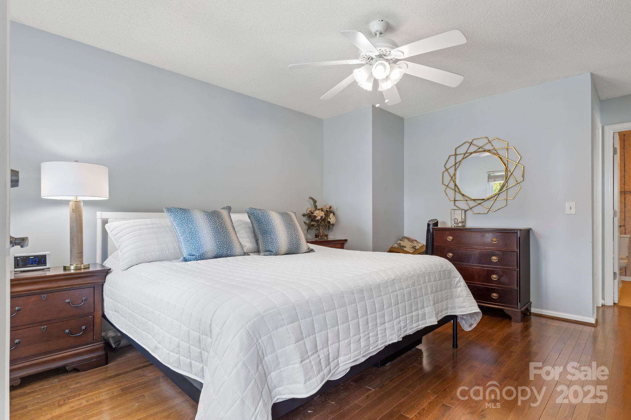 719 Southwest Drive Davidson, NC 28036 - Photo 12 of 27 a bedroom with a bed a chandelier and a table
