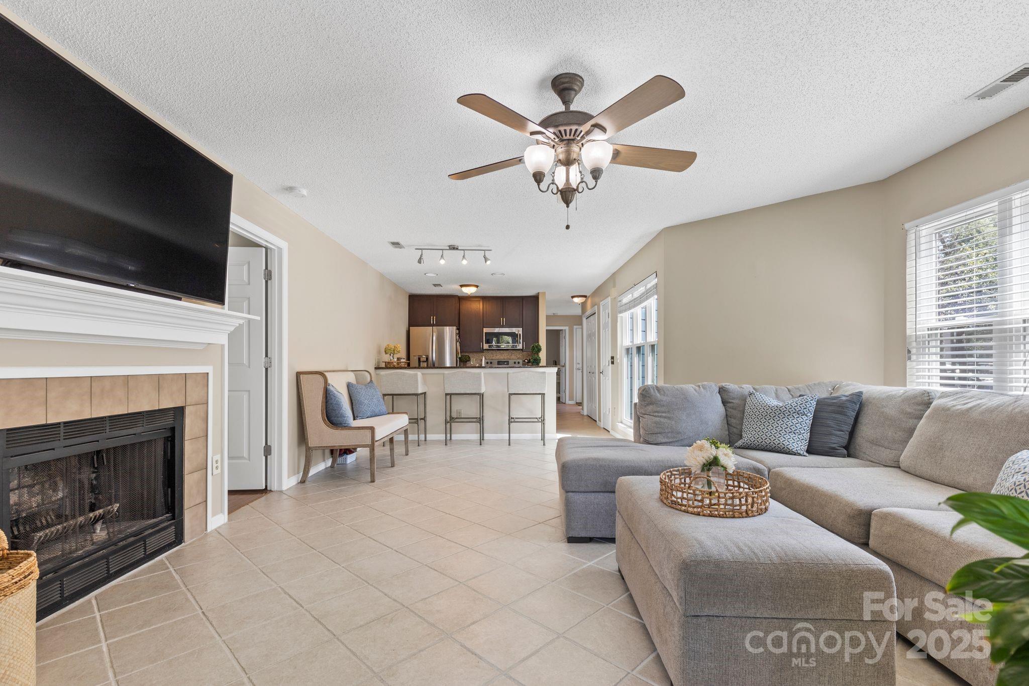 719 Southwest Drive Davidson, NC 28036 - Photo 5 of 27 a living room with furniture a fireplace and a flat screen tv