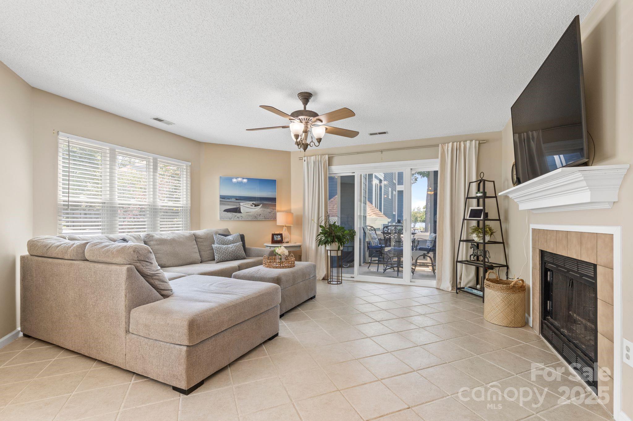 719 Southwest Drive Davidson, NC 28036 - Photo 7 of 27 a living room with furniture a fireplace and a flat screen tv
