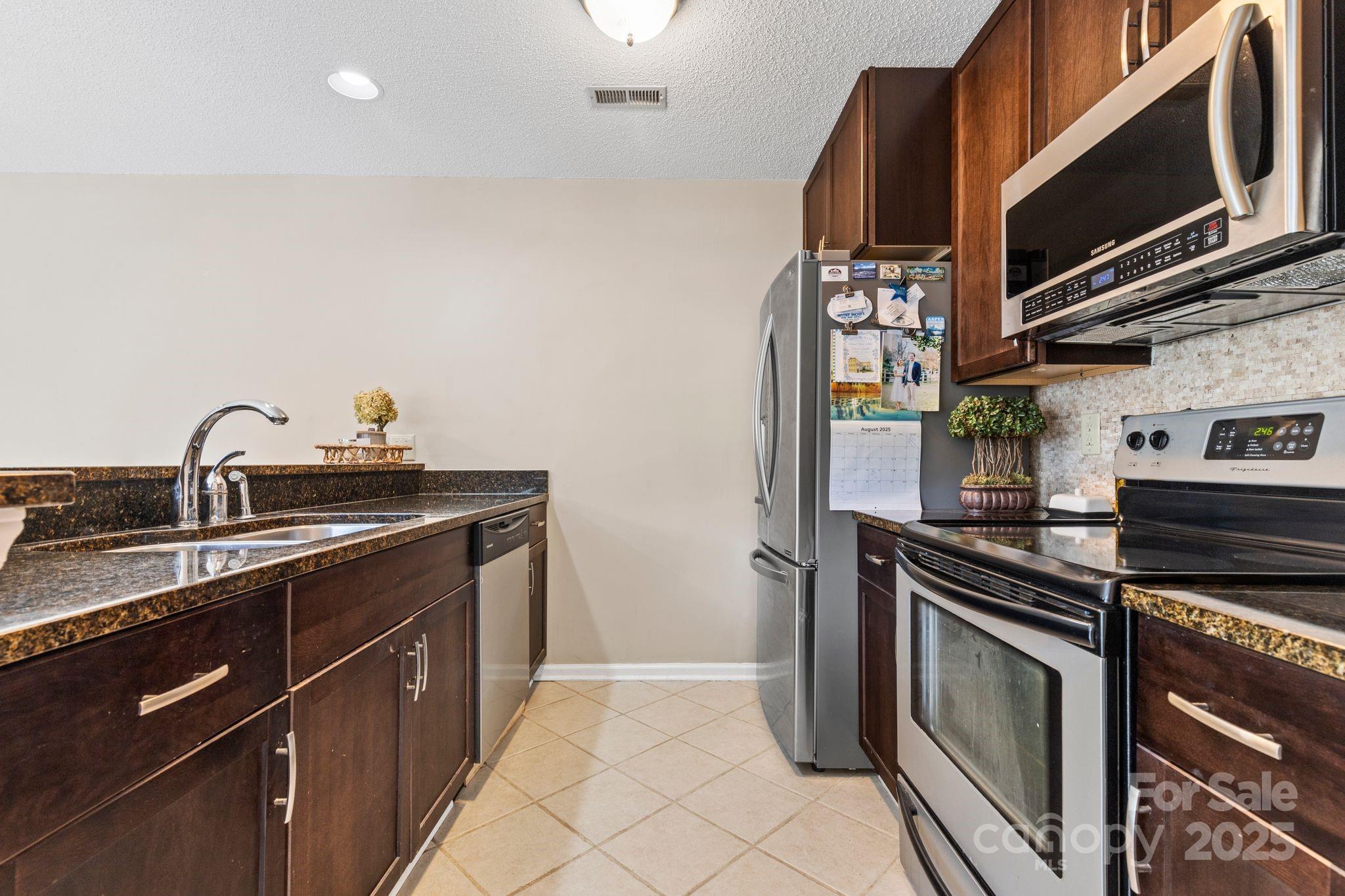 719 Southwest Drive Davidson, NC 28036 - Photo 9 of 27 a kitchen with stainless steel appliances granite countertop a stove and a microwave