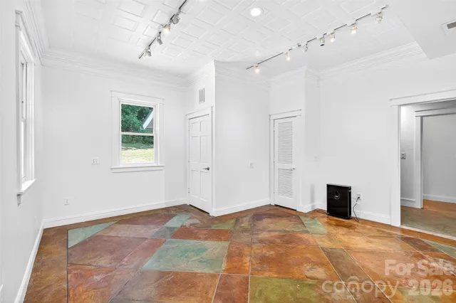 a view of a livingroom with a chandelier fan and windows