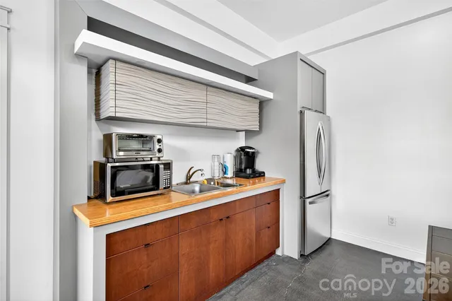 a kitchen with refrigerator a stove a sink and storage