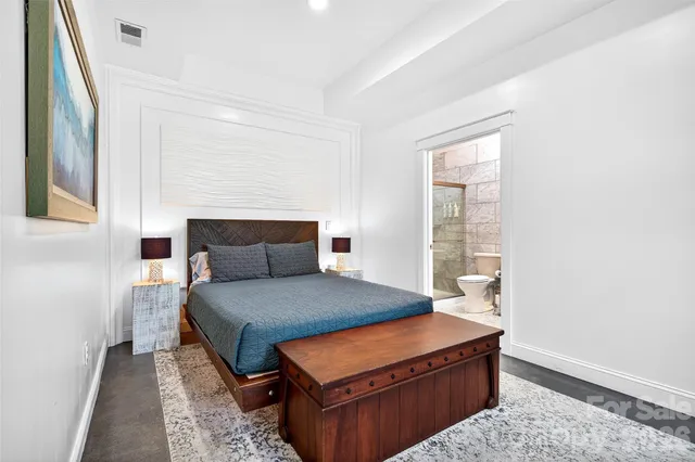 a bed sitting in a bedroom next to a window with lamp