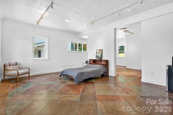 a spacious bedroom with a bed a table and chair
