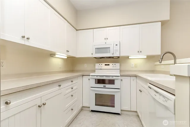 a kitchen with cabinets appliances and a sink
