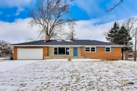 a front view of house with yard and trees around