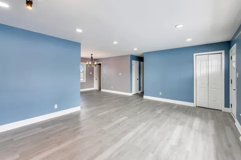 a view of an empty room with wooden floor