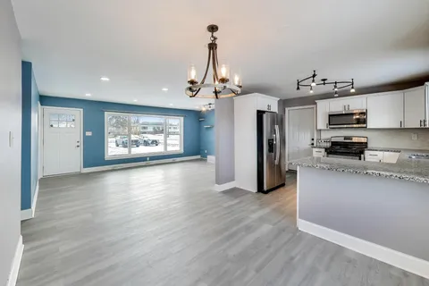 a view of a kitchen with a sink a refrigerator and window