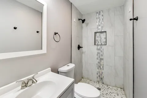 a bathroom with a sink toilet and shower