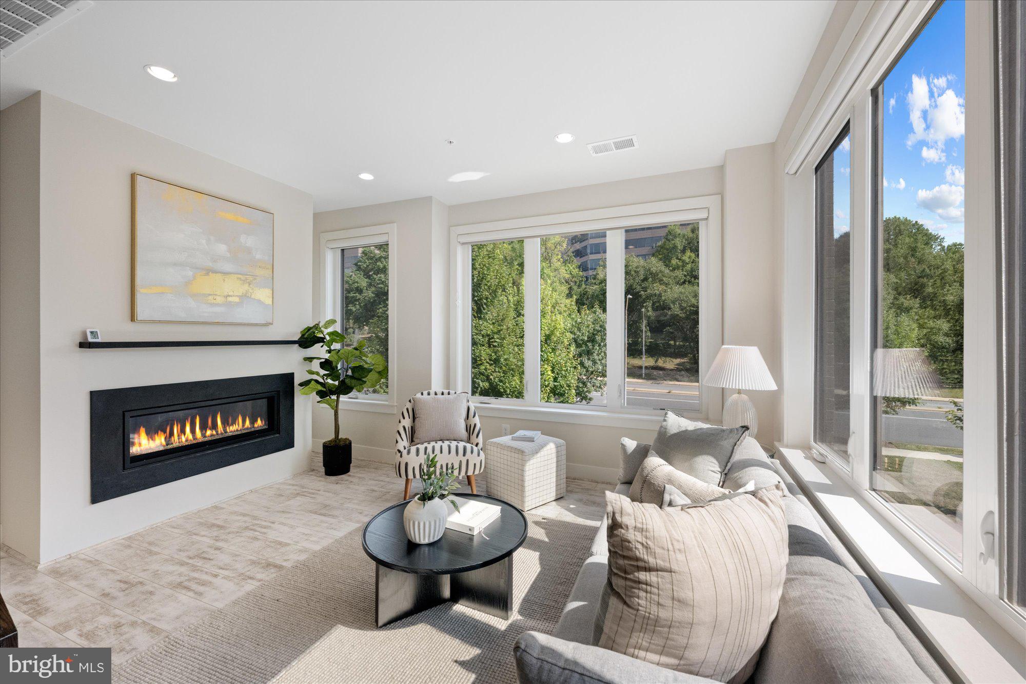 6597 Rock Spring Drive Bethesda, MD 20817 - Photo 21 of 37 a living room with furniture a fireplace and a large window