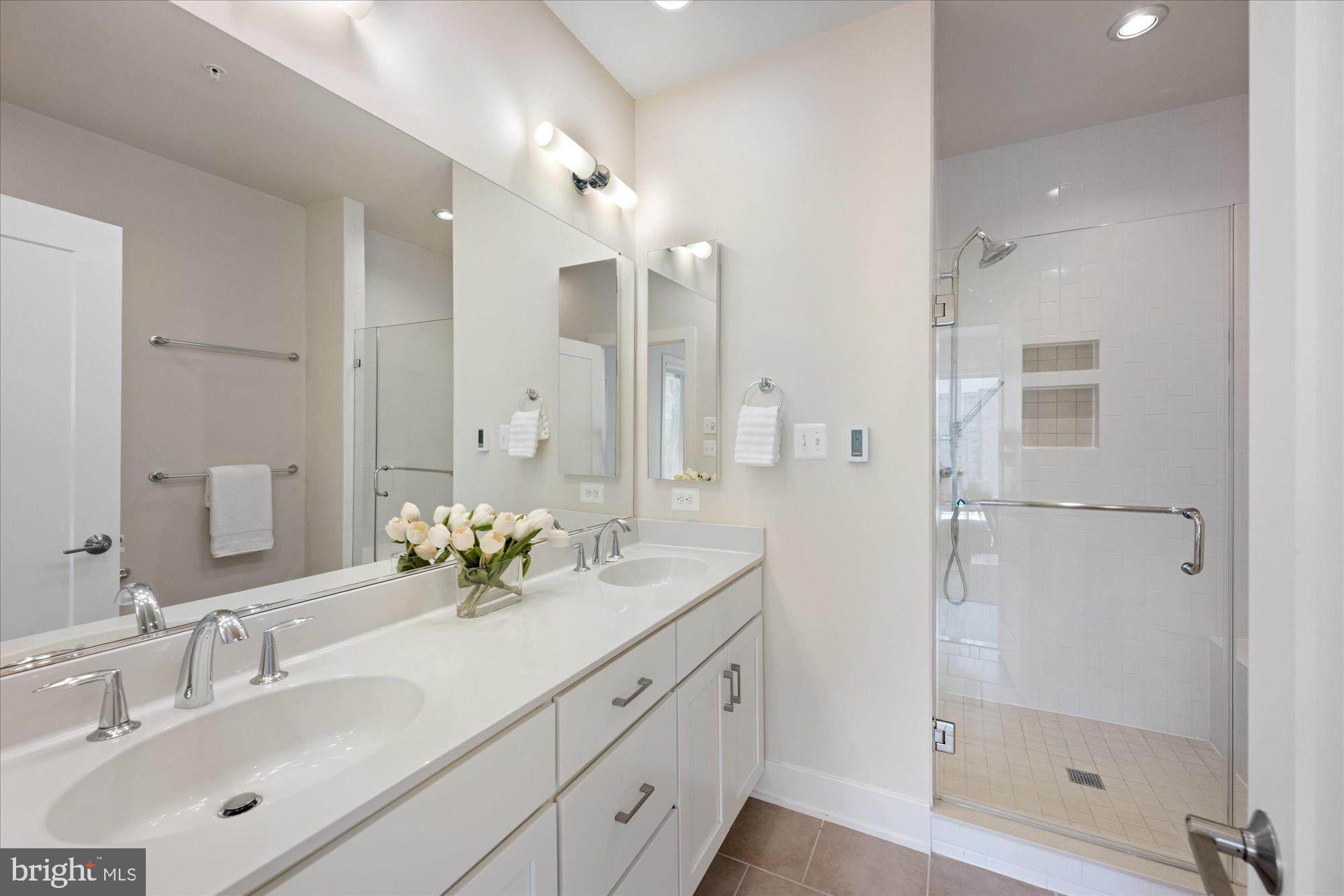 6597 Rock Spring Drive Bethesda, MD 20817 - Photo 24 of 37 a bathroom with a double vanity sink and shower