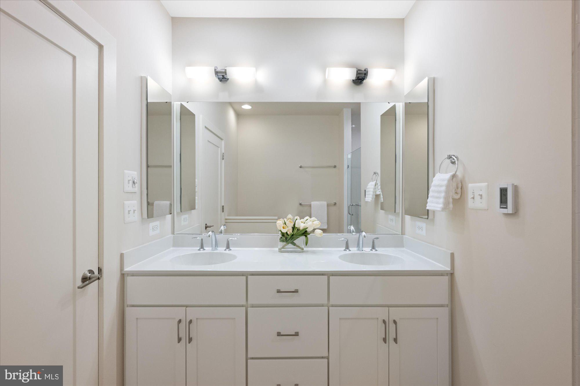 6597 Rock Spring Drive Bethesda, MD 20817 - Photo 25 of 37 a bathroom with a double vanity sink and a mirror