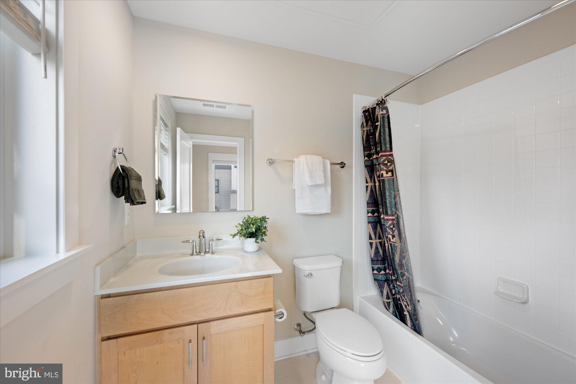 6597 Rock Spring Drive Bethesda, MD 20817 - Photo 33 of 37 a bathroom with a sink a toilet a mirror and shower