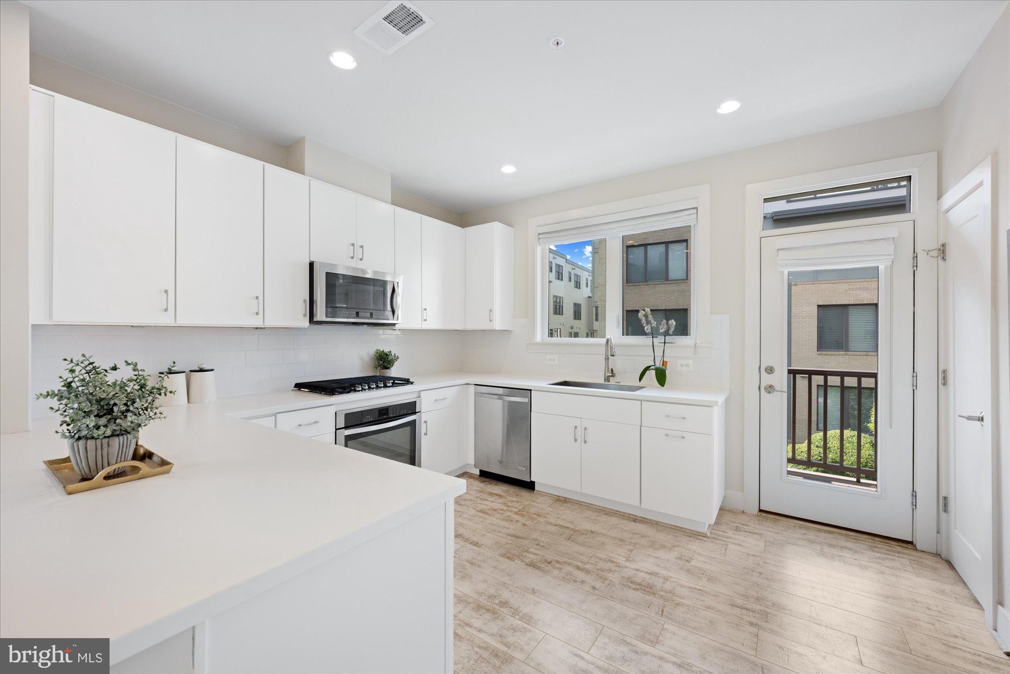 6597 Rock Spring Drive Bethesda, MD 20817 - Photo 9 of 37 a kitchen with granite countertop white cabinets and white appliances