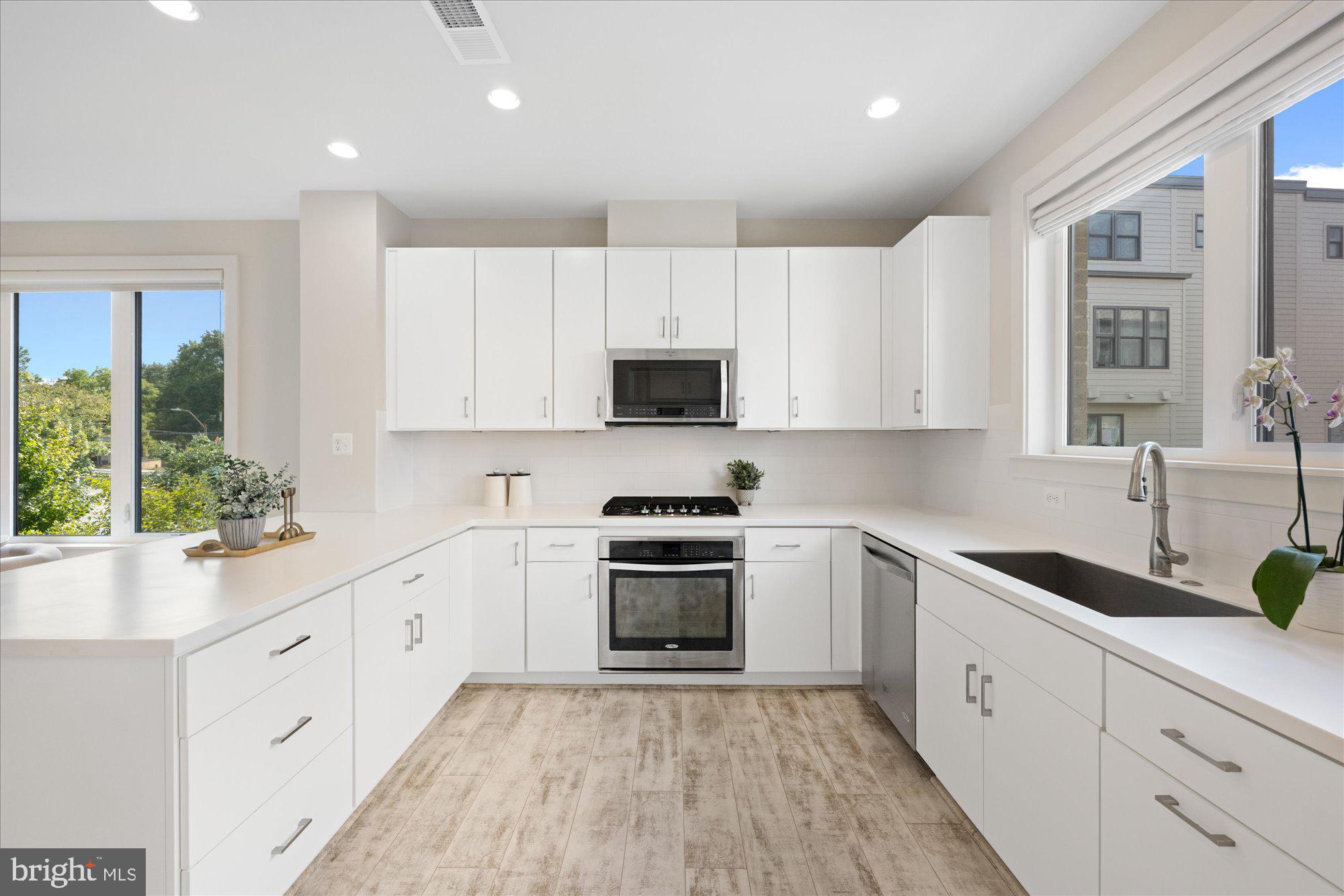 6597 Rock Spring Drive Bethesda, MD 20817 - Photo 10 of 37 a kitchen with granite countertop white cabinets and white appliances