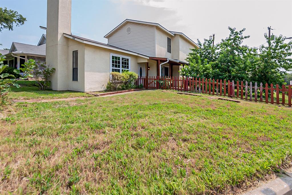a front view of house with yard and trees in the background
