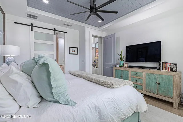 a bedroom with a bed and a flat screen tv