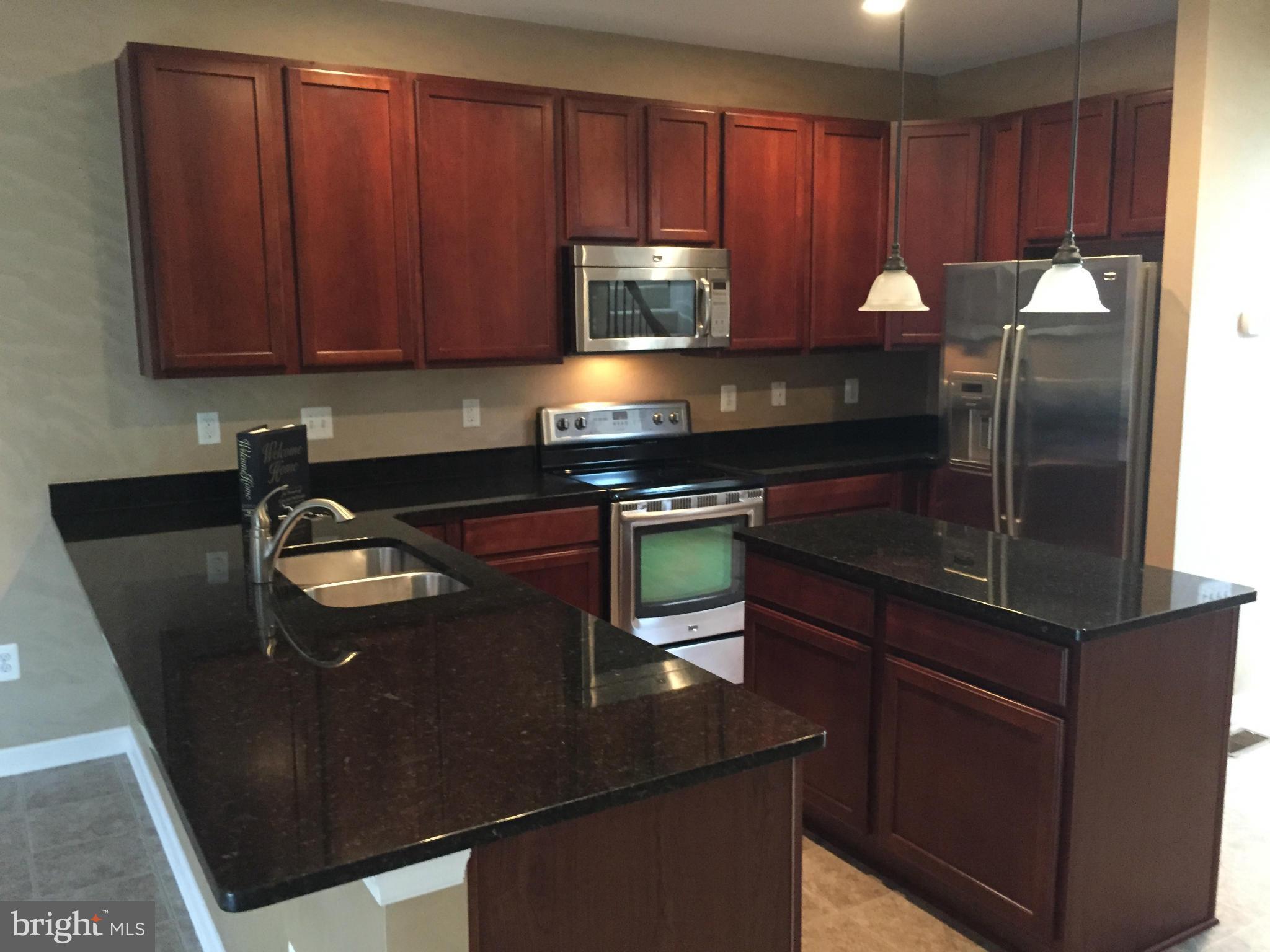 26 Riparian Lane Ranson, WV 25438 - Photo 3 of 28 a kitchen with granite countertop wood cabinets and stainless steel appliances