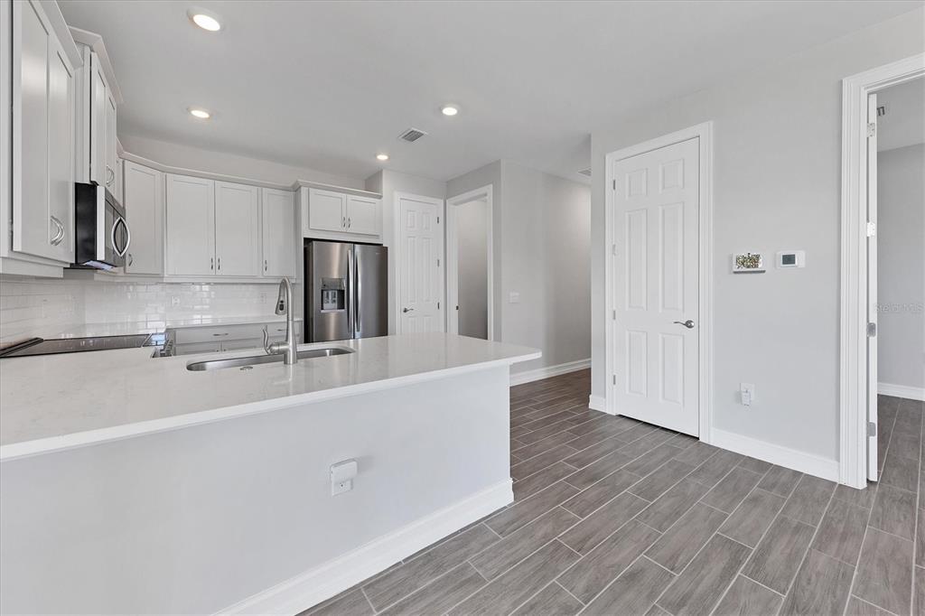 111 Ibiza Loop Venice, FL 34292 - Photo 12 of 37 a large kitchen with stainless steel appliances a large counter top a sink and a refrigerator
