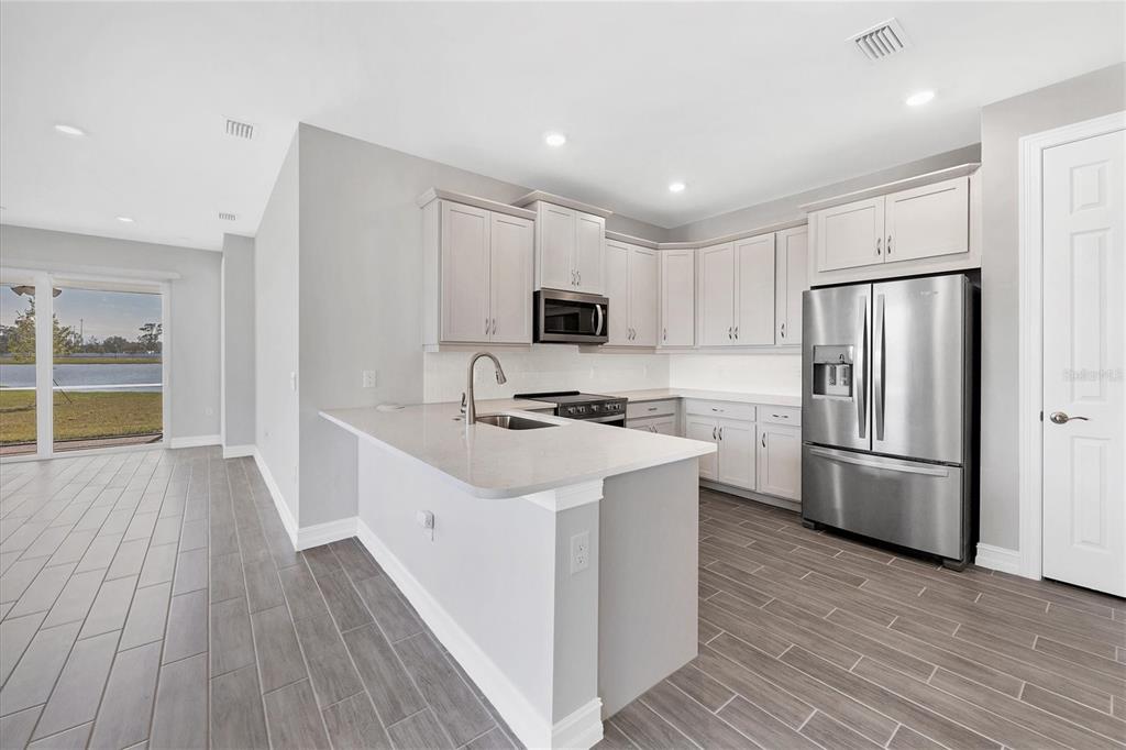 111 Ibiza Loop Venice, FL 34292 - Photo 13 of 37 a kitchen with a sink a microwave a refrigerator and cabinets