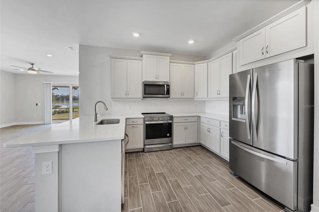 111 Ibiza Loop Venice, FL 34292 - Photo 15 of 37 a kitchen with stainless steel appliances a refrigerator sink and microwave