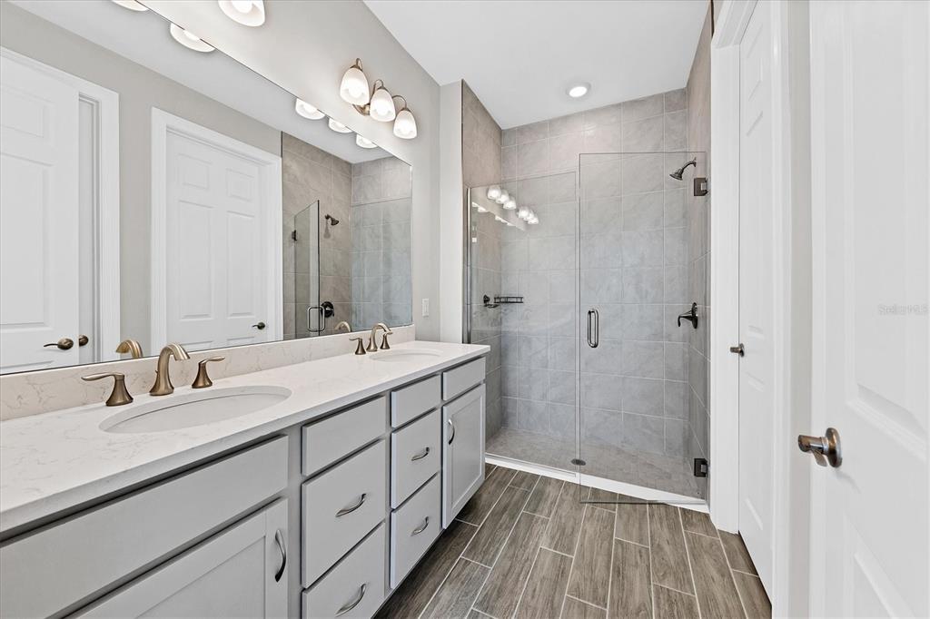 111 Ibiza Loop Venice, FL 34292 - Photo 22 of 37 a bathroom with a double vanity sink mirror and shower
