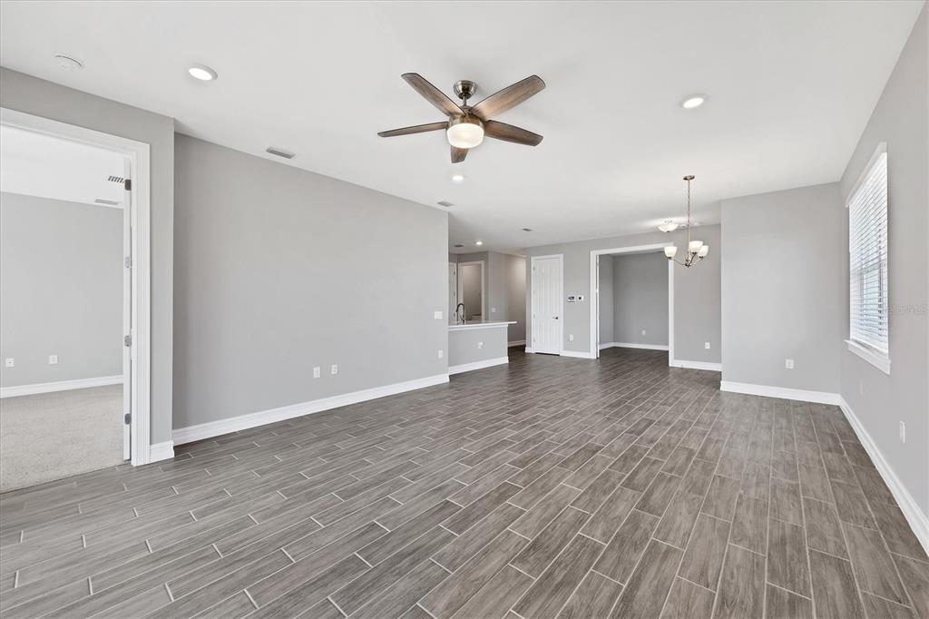 111 Ibiza Loop Venice, FL 34292 - Photo 8 of 37 a view of an empty room with wooden floor and a ceiling fan