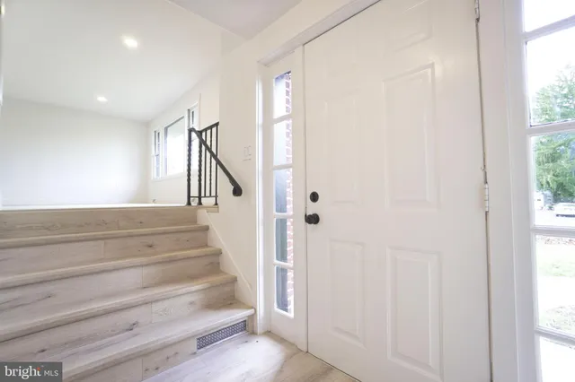 a view of entryway with wooden floor and front door