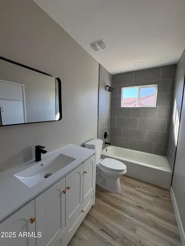 a bathroom with a double vanity sink toilet a shower and a bathtub
