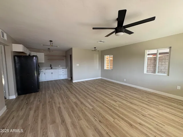 a view of empty room with wooden floor and window